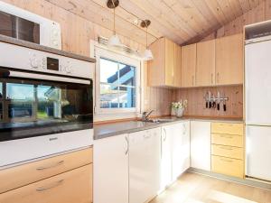 a kitchen with white cabinets and a sink at 6 person holiday home in Hemmet in Falen