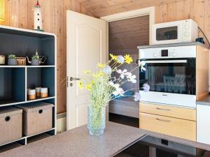 a kitchen with a vase of flowers on a counter at 6 person holiday home in Hemmet in Falen