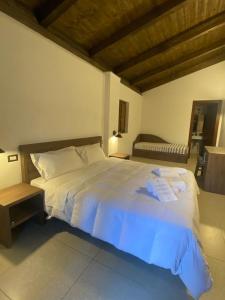 1 dormitorio con 1 cama blanca grande y toallas. en Elda Hotel en Vico del Gargano