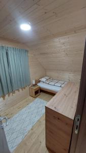 a bedroom with a bed in a wooden cabin at Planinska kuća Jabuka in Prijepolje