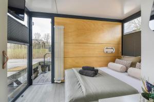 泽沃德Cosy tiny houseboats near beach and restaurants by Weltevreden Experience的一间带大床的卧室和一个阳台