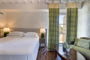 a bedroom with a large bed with green curtains at Dorion Hotel in Ornos