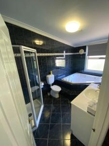 La salle de bains est pourvue d'une baignoire, de toilettes et d'un lavabo. dans l'établissement Location location: Melbourne street views, à Adélaïde