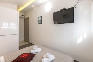 Pokój z łóżkiem z ręcznikami i telewizorem na ścianie w obiekcie Villa Desire with private pool and sea view w mieście Sevid