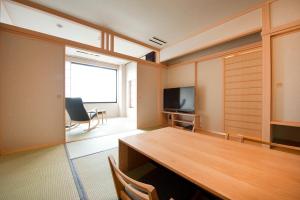 a conference room with a table and a television at Kangetsuen in Otofuke