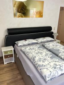 Schlafzimmer mit einem Bett mit einer schwarzen und weißen Bettdecke in der Unterkunft Ferienwohnung Jeremy in Bad Tölz