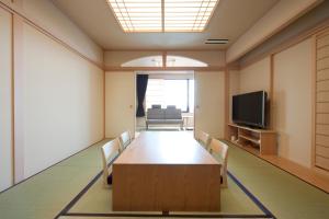 a conference room with a table and chairs and a tv at Kangetsuen in Otofuke