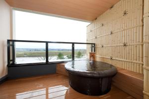 a large tub in a room with a large window at Kangetsuen in Otofuke