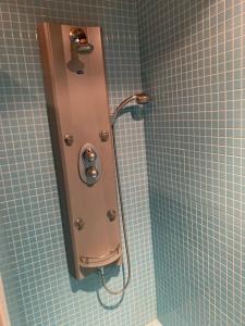 eine Dusche im Bad mit blauen Fliesen in der Unterkunft Apartamentos San José in Zafra