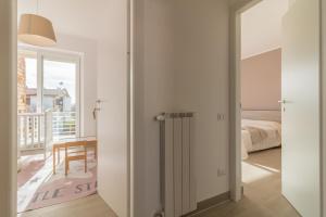 Schlafzimmer mit einer Tür, die in ein Zimmer mit einem Bett führt in der Unterkunft Villa luminosa ed elegante a Sutri in Sutri
