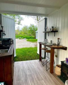 an outdoor kitchen with a view of a yard at Trethowels Grey Hidden hut in St Austell