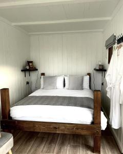 1 dormitorio con 1 cama grande con sábanas blancas en Trethowels Grey Hidden hut, en St Austell