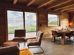 a dining room with a table and chairs and mountains at Chalet Vue Mont-Blanc imprenable in Combloux