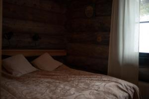 uma cama num quarto com uma janela e uma cortina em Villa Sukka em Kuusamo