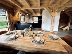 a wooden table with plates and dishes on top of it at Chalet Vue Mont-Blanc imprenable in Combloux