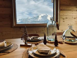 a table with a view of a mountain from a window at Chalet Vue Mont-Blanc imprenable in Combloux
