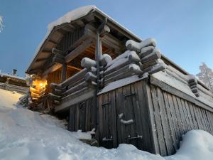 Cabaña de madera con nieve en el techo en Villa Sukka en Kuusamo