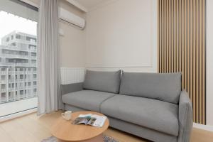 ein Wohnzimmer mit einem Sofa und einem Tisch in der Unterkunft Wola Spacious Flat with Air Conditioning & Balcony by Renters in Warschau
