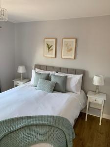 1 dormitorio con 1 cama blanca grande y 2 mesas en Kincraig Apartment en Ayr