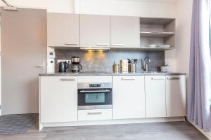 eine Küche mit weißen Schränken und einem Backofen in der Unterkunft Newly build Loft city center Delft XL Family apartment in Delft