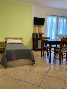 um quarto com uma cama e uma mesa com cadeiras em Lavini em Marco