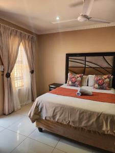 a bedroom with a large bed and a window at Suits Guest house & bar in Carletonville