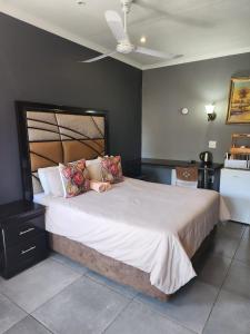 ein Schlafzimmer mit einem großen Bett in einem Zimmer in der Unterkunft Suits Guest house & bar in Carletonville