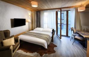 una camera d'albergo con letto, scrivania e TV di Chalets Jasná Collection - Apartments a Demänovská Dolina