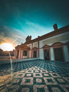 a building with a tiled courtyard with the sunset in the background at Villa del Gattopardo in Palermo