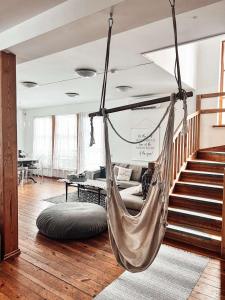 uma rede pendurada no tecto numa sala de estar em Farm hostel - The house em Elektrėnai