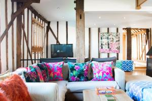 a living room with a white couch with colorful pillows at Luxury, countryside barn conversion with Hot tub in Kent