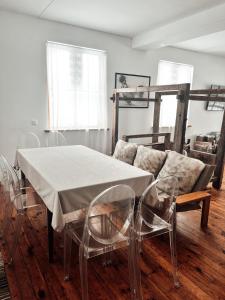 a dining room with a table and chairs and a couch at Farm hostel - The house in Elektrėnai
