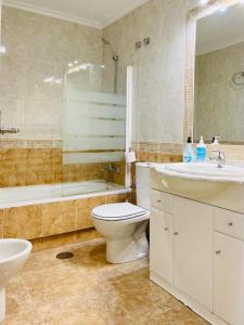 a bathroom with a toilet and a sink and a tub at Beautiful location in Cabo Roig with a private roof top terrace at Playamarina II in Orihuela +31 photos