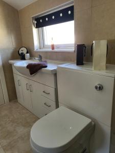a bathroom with a toilet and a sink and a window at Executive Central Apartment - AR in Southport