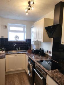 a kitchen with a sink and a dishwasher at Executive Central Apartment - AR in Southport