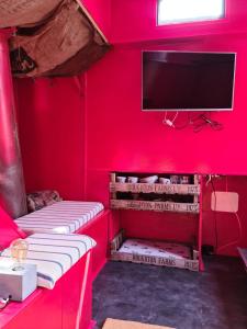 um quarto com paredes vermelhas e uma televisão de ecrã plano em Kaleb The Combine em Boston