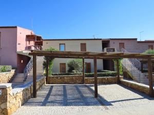 a view of a building with a wooden structure at Reihenhaus Nr. 8 mit Pool und super Meersicht in Porto Pozzo