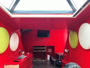 um quarto com uma parede vermelha e uma clarabóia em Kaleb The Combine em Boston