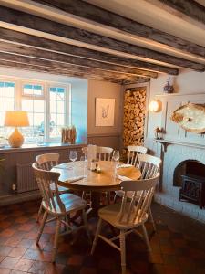 a dining room with a table and chairs and a fireplace at Gazelle Hotel in Menai Bridge