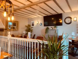 a living room with a table and a clock on the wall at Gazelle Hotel in Menai Bridge