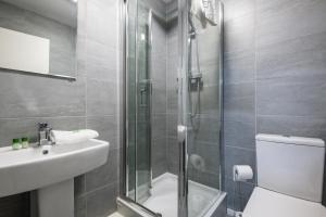 a bathroom with a shower and a toilet and a sink at Fabulous Quayside Apartment with Free Parking in Liverpool