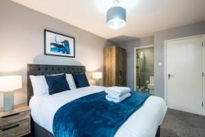 una camera da letto con un grande letto con una coperta blu di Fabulous Quayside Apartment with Free Parking a Liverpool
