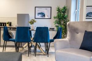 a dining room with blue chairs and a table at Fabulous Quayside Apartment with Free Parking in Liverpool