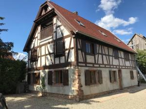 un ancien bâtiment avec un toit rouge dans l'établissement Paisible logement tout équipé pour 1 à 6 personnes, à Ebersheim