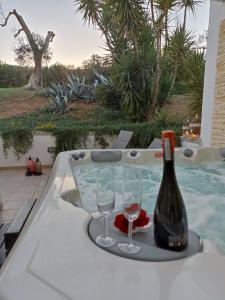 einen Whirlpool mit einer Flasche Wein und zwei Gläsern in der Unterkunft Casa De Luca in Arnesano