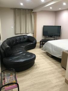 salon z czarną skórzaną kanapą i łóżkiem w obiekcie Paisible logement tout équipé pour 1 à 6 personnes w mieście Ebersheim