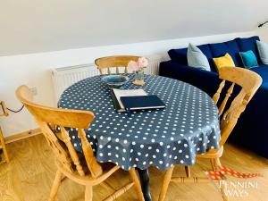 una mesa con un mantel de lunares azul y blanco en The Boat House, Northumberland Village Location, en Brampton