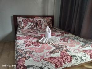 a bed with a head board with butterflies on it at Sealey's Inn in Sipalay