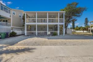 a large apartment building with a large porch at Coquina Cottage B home in Anna Maria
