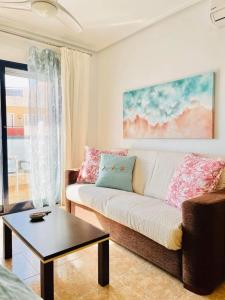 a living room with a couch and a table at Beautiful location in Cabo Roig with a private roof top terrace at Playamarina II in Orihuela
